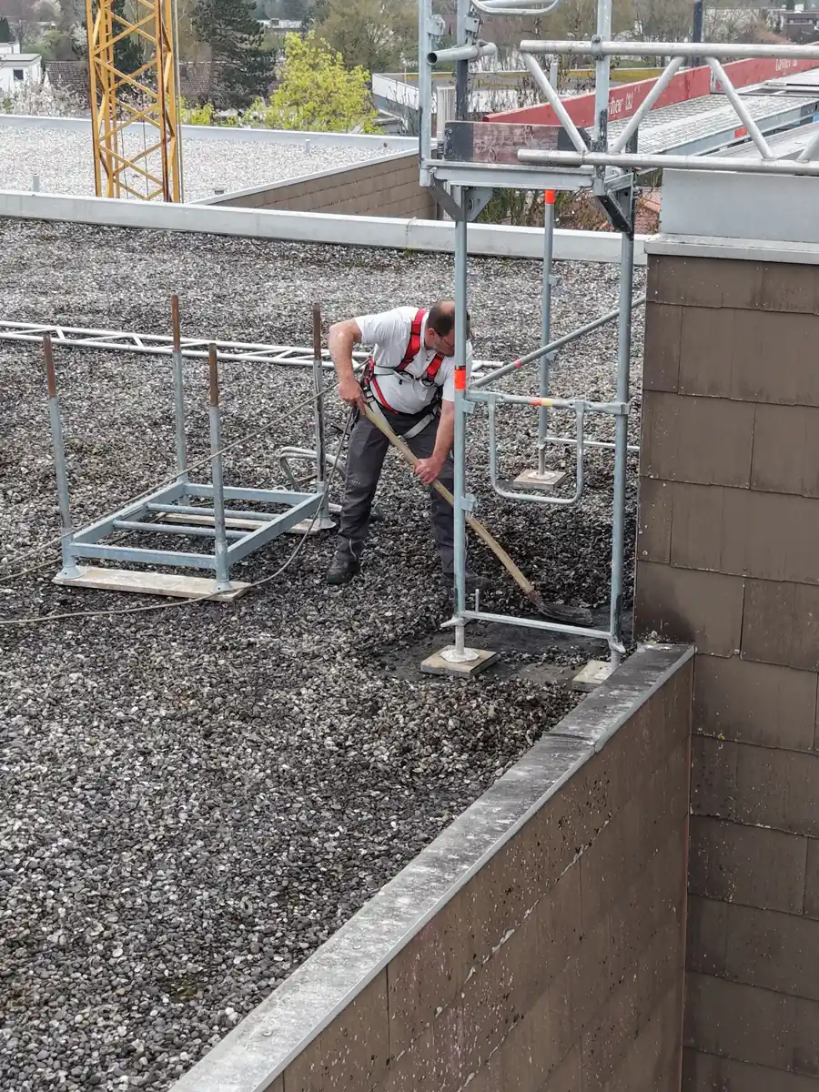 Dachdecker bei Sanierungsarbeiten auf einem Kiesdach